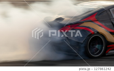 Car drifting, Blurred image diffusion race drift car with lots of smoke from burning tires on speed track, Car drifting on speed track, Professional driver driv drifting car. 127861242