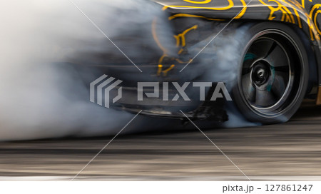 Car drifting, Blurred image diffusion race drift car with lots of smoke from burning tires on speed track, Car drifting on speed track, Professional driver driv drifting car. 127861247