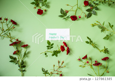 Arrangement of small red roses isolated on green Arrangement of small red roses isolated on green 127861385