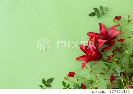 Lush red lilies with red roses on green background 127861389