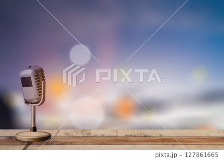 Vintage microphone on wooden table with blurred bokeh lights background Vintage microphone on wooden table with blurred bokeh lights background 127861665