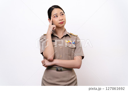 A curious woman in a Thai asian teacher uniform is looking to the side. she is thinking something A curious woman in a Thai asian teacher uniform is looking to the side. she is thinking something 127861692