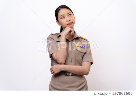 A curious woman in a Thai asian teacher uniform is looking to the side. she is thinking something 127861693