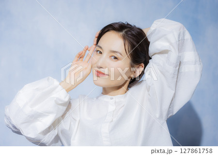 白いブラウスの伸びをする女性　 127861758