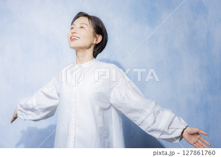 白いブラウスの伸びをする女性　 127861760