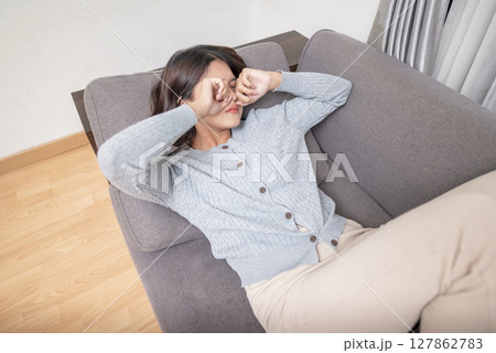 Indonesian southeast asian woman in the living room with mental health, fatigue, and sad problems. Faced with depression, frustration, tiredness, headaches, and stress. Healthcare concept Indonesian southeast asian woman in the living room with mental health, fatigue, and sad problems. Faced with depression, frustration, tiredness, headaches, and stress. Healthcare concept 127862783