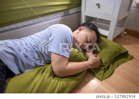 Indonesian southeast asian husband sleeping separately from his wife in the bedroom. Having a crisis and difficulties in a relationship 127862914