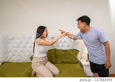 Indonesian southeast asian couple arguing in the bedroom. Having a crisis and difficulties in a relationship Indonesian southeast asian couple arguing in the bedroom. Having a crisis and difficulties in a relationship 127862959