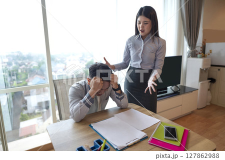 Indonesian southeast asian businessman gets scolded by his boss for being late or for the stress of deadlines. Cellphone and paperwork on the table. Business concept 127862988