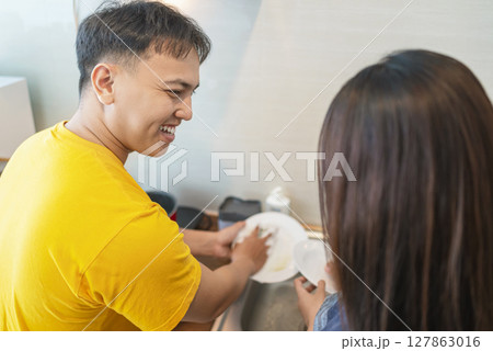 Indonesian southeast asian couple family washing dishes together in the modern kitchen. Household routine concept 127863016