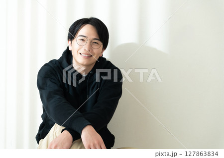 壁際に座る男性 127863834