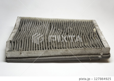 cabin air filter, wear out, dirty, with clogged deformed grid of carbon filtering media and foam rubber sealing strip on edge cabin air filter, wear out, dirty, with clogged deformed grid of carbon filtering media and foam rubber sealing strip on edge 127864925