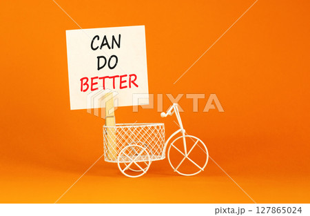 Can do better symbol. Concept words Can do better on beautiful white paper on wooden clothespin. Miniature bicycle. Beautiful orange background. Business and can do better concept. Copy space. 127865024