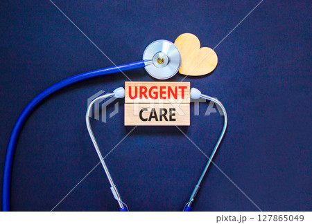 Urgent care symbol. Concept words Urgent care on beautiful wooden blocks. Wooden heart and stethoscope. Beautiful black background. Medical healthy lifestyle urgent care concept. 127865049