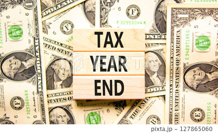 Tax year end symbol. Concept words Tax year end on beautiful wooden blocks. Dollar bills. Beautiful background from dollar bills. Business tax year end concept. Copy space. Tax year end symbol. Concept words Tax year end on beautiful wooden blocks. Dollar bills. Beautiful background from dollar bills. Business tax year end concept. Copy space. 127865060