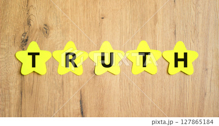 Truth symbol. Concept word Truth on beautiful yellow paper stars. Beautiful wooden table wooden background. Business lifestyle truth concept. Copy space. 127865184