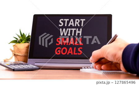 Start with small goals symbol. Concept words phrase Start with small goals on beautiful black tablet. Businessman's hand. Beautiful white background. Business Start with small goals concept Copy space 127865496