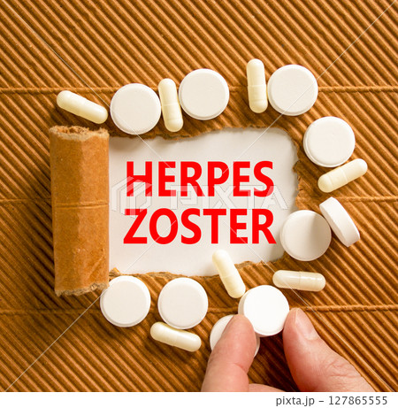 Herpes zoster symbol. Concept words Herpes zoster on beautiful white paper. White pills tablets. Doctor's hand. Beautiful brown background. Medical healthy lifestyle herpes zoster concept. 127865555