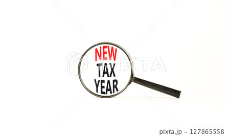 New tax year symbol. Concept words New tax year on beautiful black magnifying glass. Beautiful white background. Business new tax year concept. Copy space. 127865558