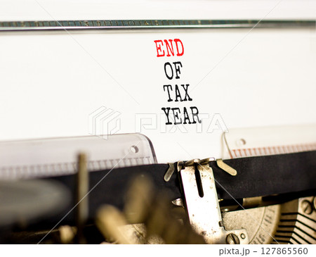 End of tax year symbol. Concept words phrase End of tax year typed on beautiful retro old typewriter. Beautiful white background. Business End of tax year concept. Copy space. 127865560