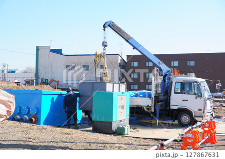 クレーン付きトラックで資材を吊り上げる作業 127867631