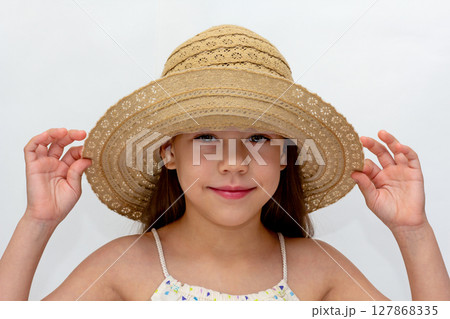 Portrait of caucasian smiling child holding straw hat on head of 6 7 years looking at camera 127868335