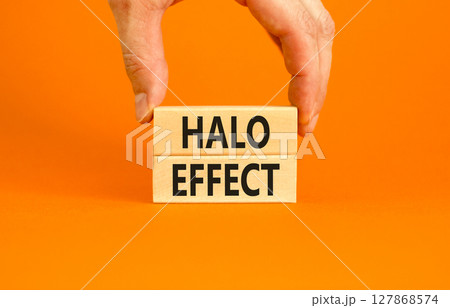 Halo effect and psychological symbol. Concept words Halo effect on beautiful wooden block. Beautiful orange background. Businessman hand. Business psychological and Halo effect concept. Copy space. Halo effect and psychological symbol. Concept words Halo effect on beautiful wooden block. Beautiful orange background. Businessman hand. Business psychological and Halo effect concept. Copy space. 127868574
