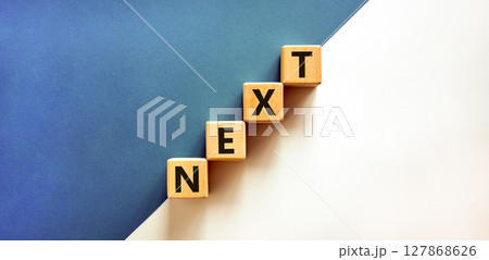 Next symbol. Concept word Next on beautiful wooden blocks. Beautiful white and blue background. Business, lifestyle, support and next concept. Copy space. Next symbol. Concept word Next on beautiful wooden blocks. Beautiful white and blue background. Business, lifestyle, support and next concept. Copy space. 127868626