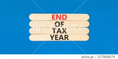 End of tax year symbol. Concept words phrase End of tax year on beautiful wooden stick. Beautiful blue paper background. Business End of tax year concept. Copy space. End of tax year symbol. Concept words phrase End of tax year on beautiful wooden stick. Beautiful blue paper background. Business End of tax year concept. Copy space. 127868674
