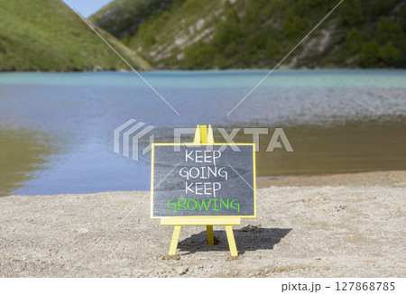 Keep going and growing symbol. Concept words phrase Keep going keep growing on beautiful black blackboard. Beautiful mountain lake background. Business Keep going and growing concept. Copy space. Keep going and growing symbol. Concept words phrase Keep going keep growing on beautiful black blackboard. Beautiful mountain lake background. Business Keep going and growing concept. Copy space. 127868785