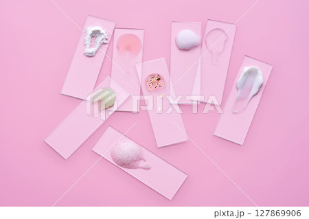 Samples of multi-colored cosmetic products on a pink background. Samples of multi-colored cosmetic products on a pink background. 127869906