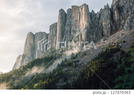Bolshoy Tkhach mountain with rocks, fog and sunlight. Caucasus Mountains. Bolshoy Tkhach mountain with rocks, fog and sunlight. Caucasus Mountains. 127870363