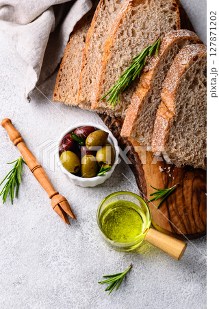 Fresh bread, olive oil and mix of olives. 127871202