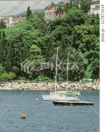 Enjoying a Sunny Day at Herceg Novi Beach With Boats and Lush Greenery in Montenegro 127871619