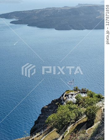 Greek flag on Santorini with a view of the sea and the nearby island 127871858