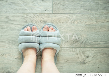 Woman in soft slippers on wooden floor, closeup. Space for text 127872797