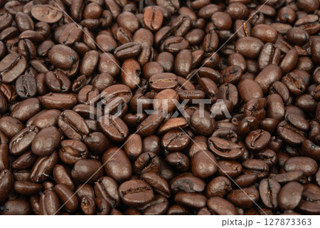 Coffee bean background. Roasted coffee beans on the entire surface. Brown coffee. Flat layout with top view. 127873363