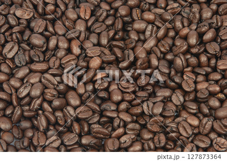 Coffee bean background. Roasted coffee beans on the entire surface. Brown coffee. Flat layout with top view. 127873364