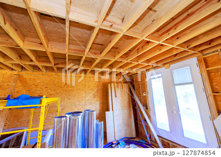 Room under construction displays wooden beams various materials, during renovation work progress. 127874854