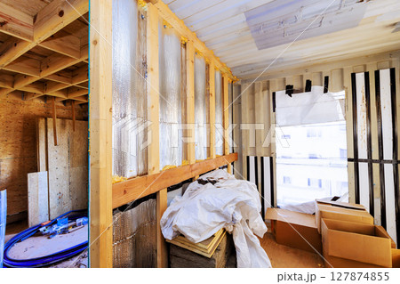 Workers are renovating an interior area, exposed insulation construction materials during daytime work 127874855
