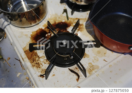 頑固な焦げ付きと油汚れが目立つガスコンロ 127875050