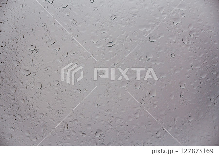 Close up view of water drops falling on glass. Rain running down on window. Rainy season, autumn Close up view of water drops falling on glass. Rain running down on window. Rainy season, autumn 127875169