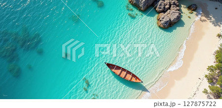 Serene aerial view of a tranquil beach, featuring a boat resting by the crystal-clear blue waters 127875722
