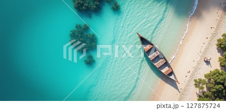 Serene aerial view of a tranquil beach, featuring a boat resting by the crystal-clear blue waters 127875724