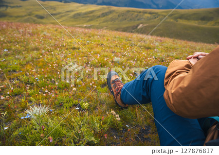 Woman backpacking on high altitude mountains top,sit on the grass 127876817