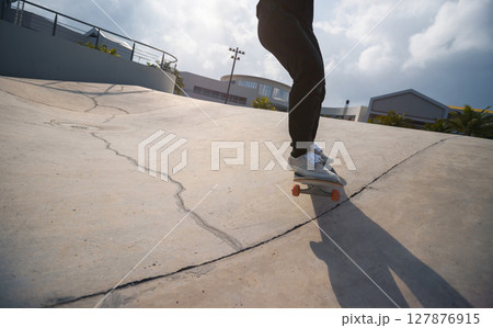 Skateboarder skateboarding at skatepark in city 127876915