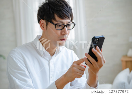 スマホを見る男性 127877972