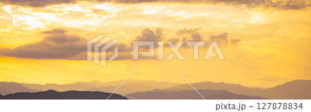 Golden sunrise over mountain range during early morning creating natural landscape background with warm light perfect for travel tourism marketing and outdoor adventure campaign materials Golden sunrise over mountain range during early morning creating natural landscape background with warm light perfect for travel tourism marketing and outdoor adventure campaign materials 127878834