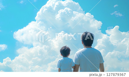 夏の空の入道雲を見上げる父親と子どもの後ろ姿 127879367