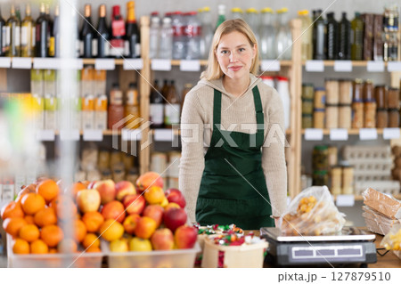 Young woman seller at counter in grocery store Young woman seller at counter in grocery store 127879510